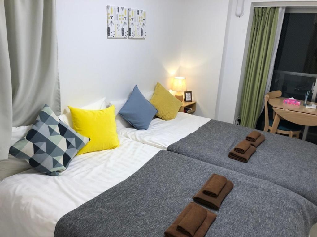 a bedroom with a bed with two slippers on it at リブシティ錦糸町参番館上層階眺望良好北欧ルーム, Akihabara 6mins, Tokyo 8 mins, Direct to Narita Airport 成田空港直達 in Tokyo