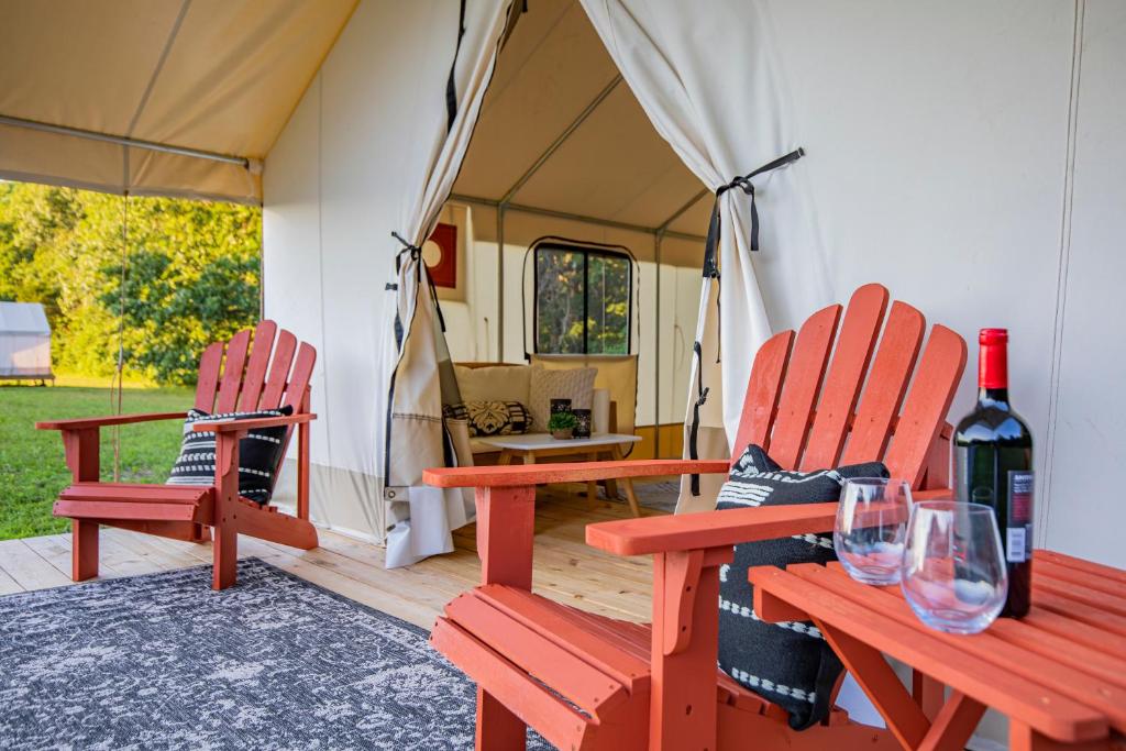 two red chairs and wine glasses in a tent at Experience Nature Glamping - Roaring River in Cassville