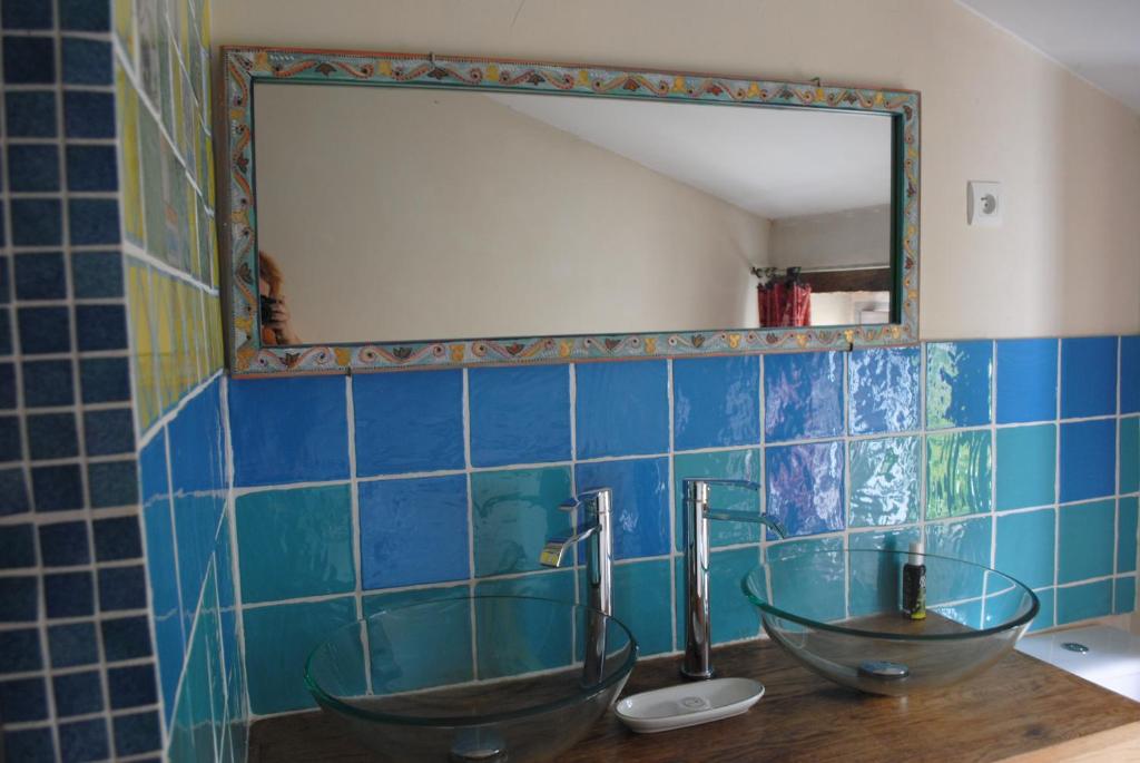 a bathroom with two sinks and a mirror at Le Ragois in Richelieu