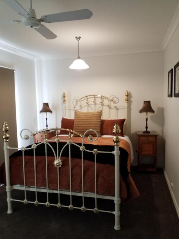 a bedroom with a bed and two lamps and a ceiling fan at Bright Deluxe No.1 TOWNHOUSE ACCOMMODATION in Bright