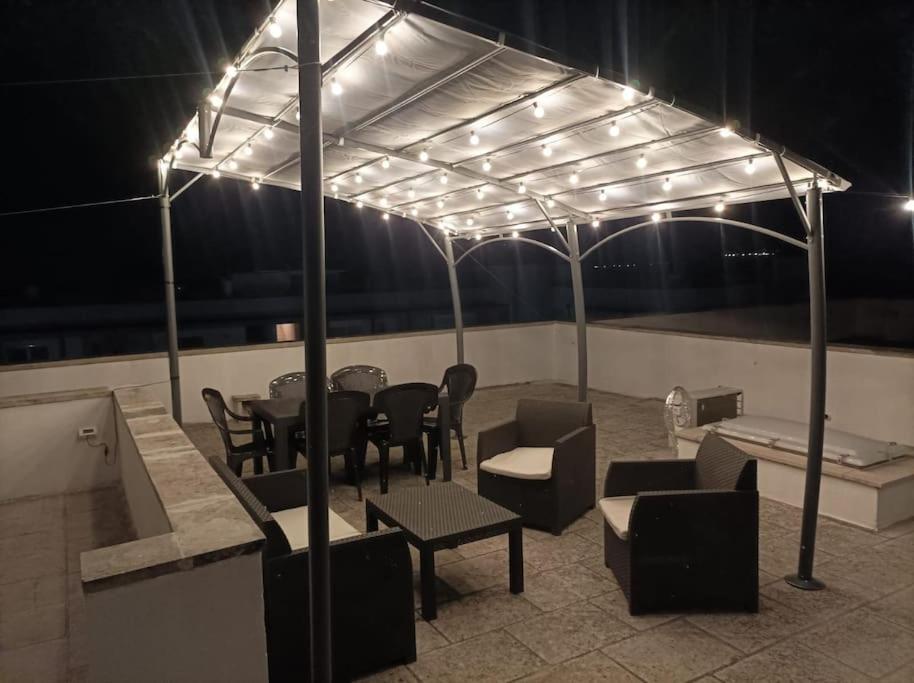 d'une terrasse avec une table, des chaises et des lumières. dans l'établissement La Terrazza, à Uggiano la Chiesa