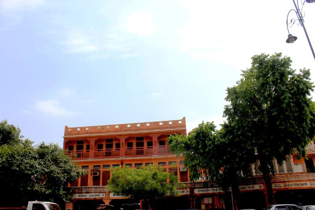 un gran edificio rojo con árboles delante de él en Friend India, en Jaipur