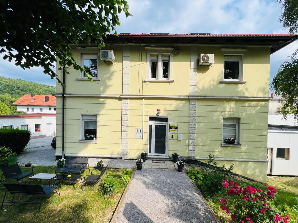 a yellow house with a pathway leading to it at Lemonwood House in Postojna