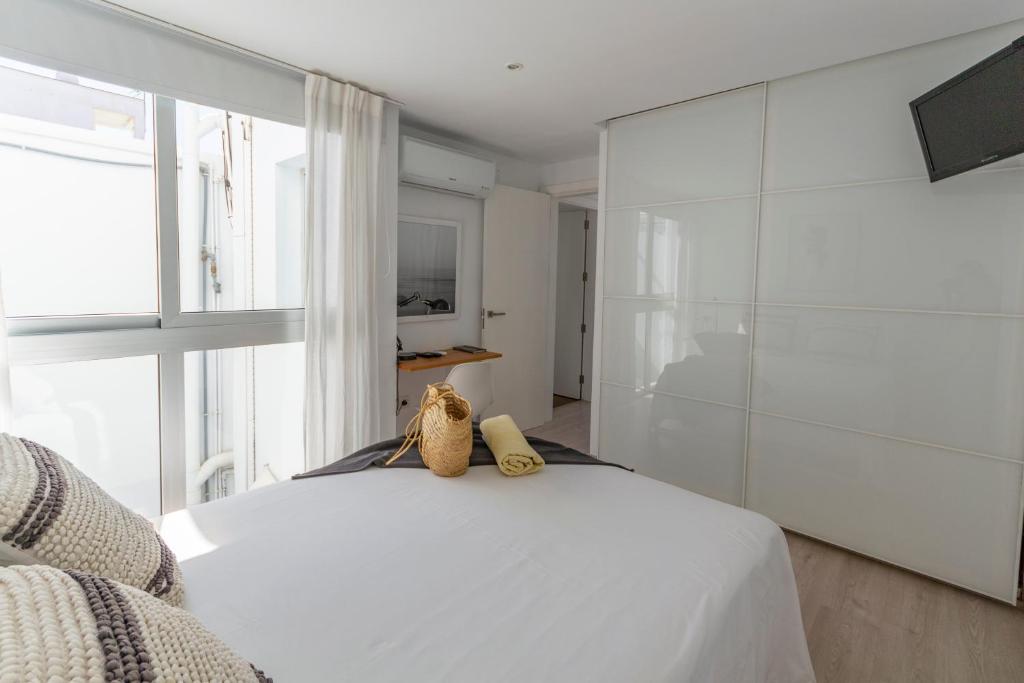 ein Schlafzimmer mit einem weißen Bett und einem großen Fenster in der Unterkunft Cozy and sea views private terrace apartment in La Playa de Arguineguín
