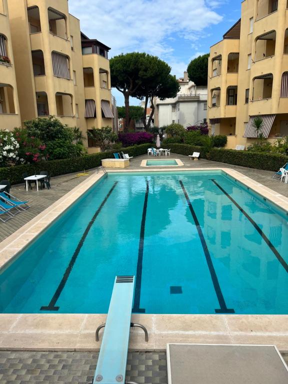 a large swimming pool in front of two apartment buildings at La casetta di Chloè residence con Piscina in Santa Marinella