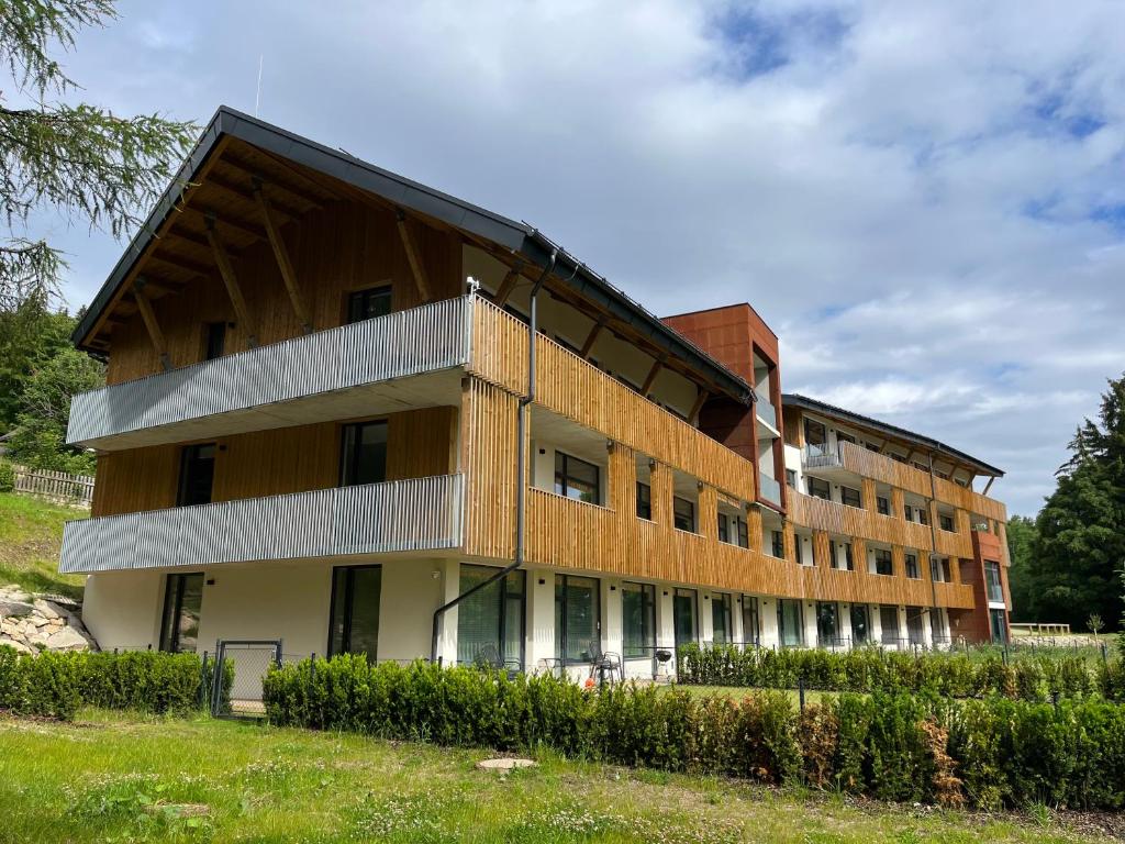 um edifício de apartamentos com uma fachada de madeira em Apartmán na Zadově em Stachy