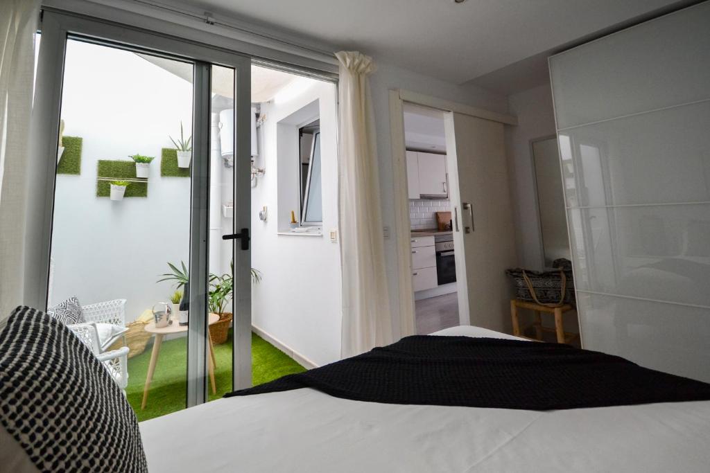 ラ・プラヤ・デ・アルグイネグインにあるLuminoso loft recién reformadoのベッドルーム1室(ベッド1台付)、キッチンへのドア
