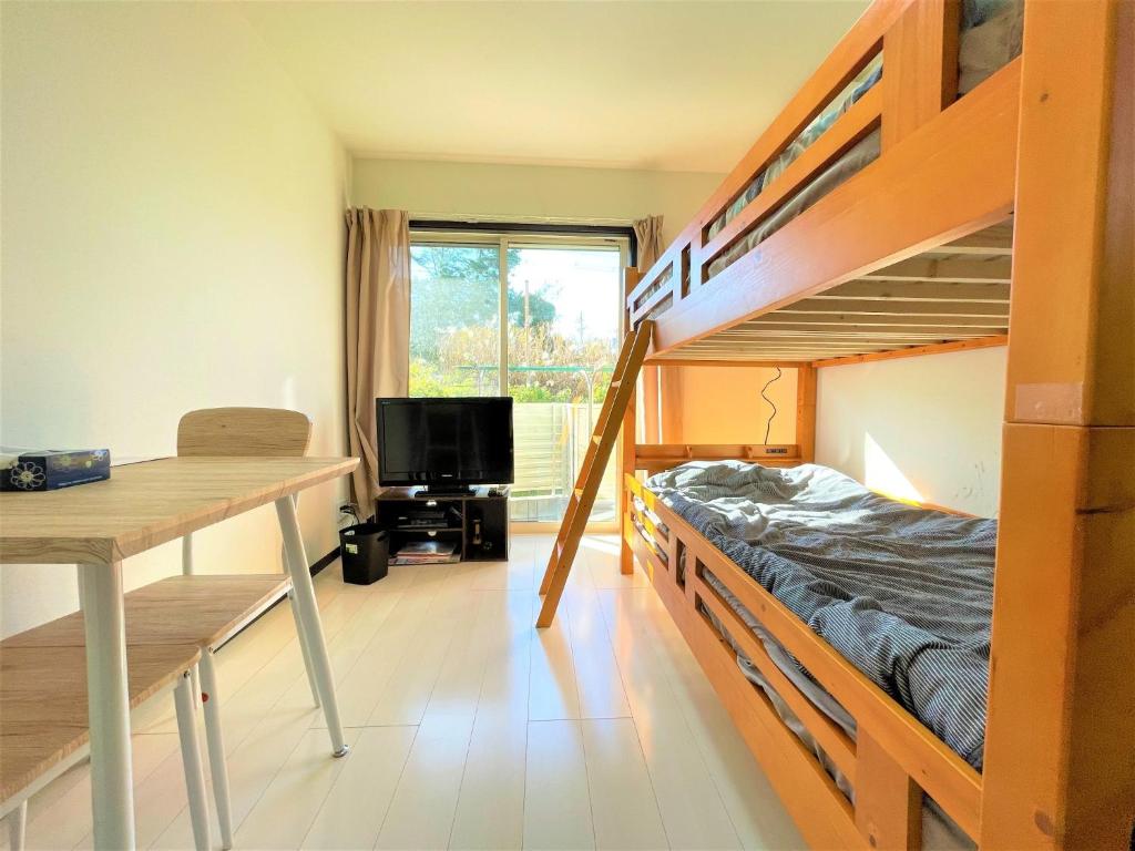 Zimmer mit einem Schreibtisch und Etagenbetten in der Unterkunft Credo Maison Kamakura - Vacation STAY 10347 in Kamakura