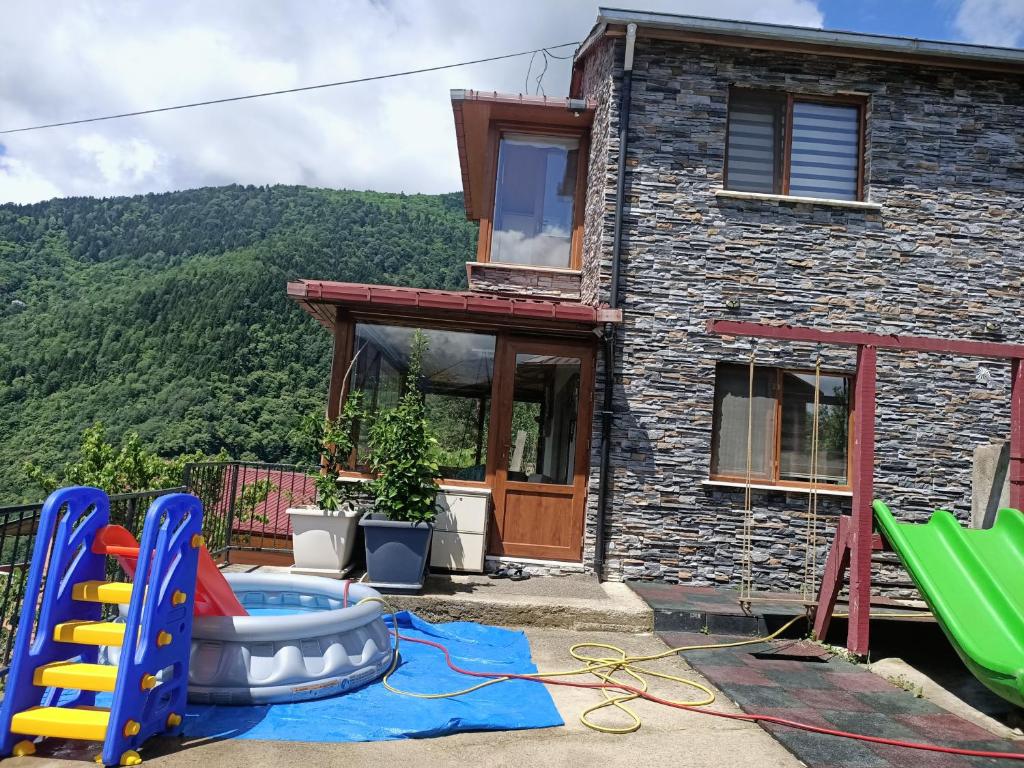 uma casa com piscina e equipamento de jogo em frente em Villa Pamuklu second floor only em Çaykara