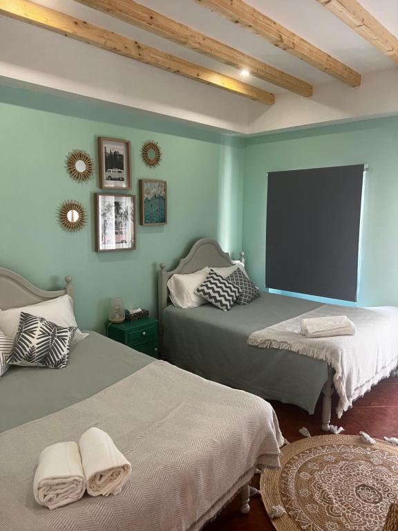 twee bedden in een kamer met groene muren bij Casa de Férias in Nazaré
