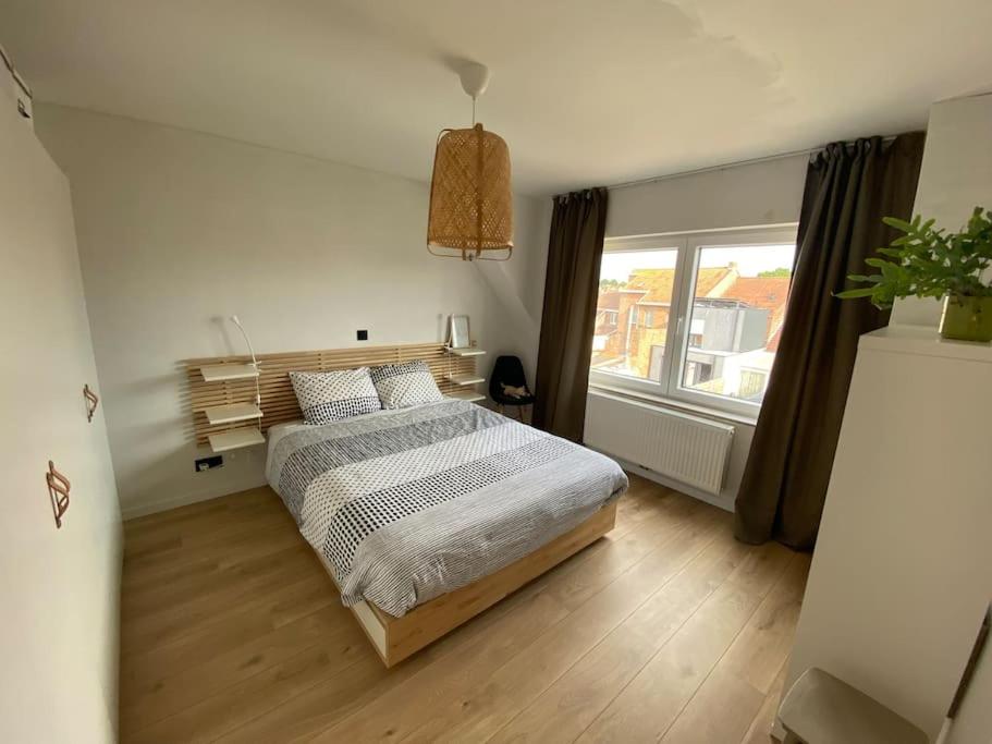 1 dormitorio con cama y ventana grande en Bel-Etage 11, en Veurne