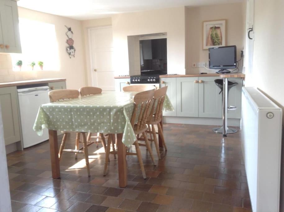 a kitchen with a table and some chairs and a television at Lynn Cottage, Newport in Newport