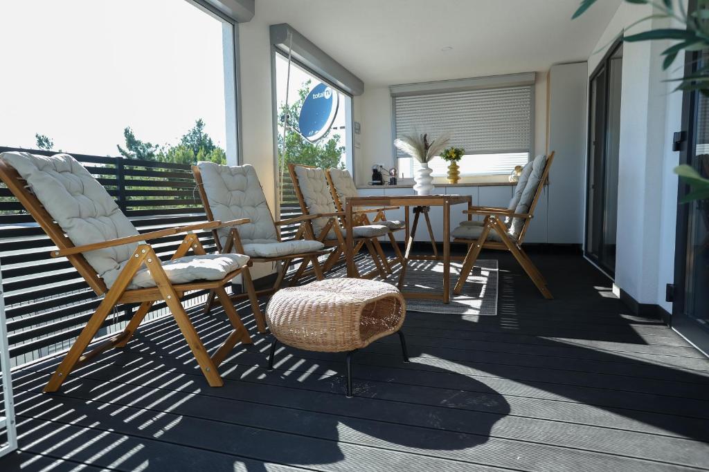 un patio con sillas y una mesa en una terraza en Mobile home Mare Blu en Rovanjska