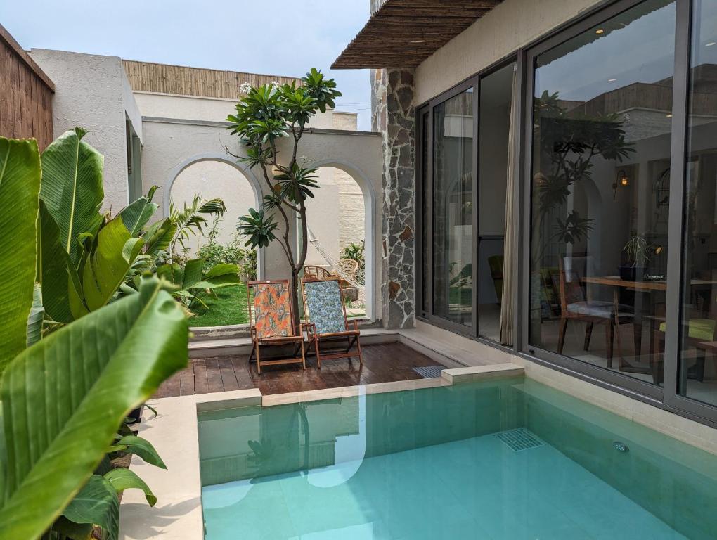 a house with a swimming pool and a patio at Cape House in Amritsar