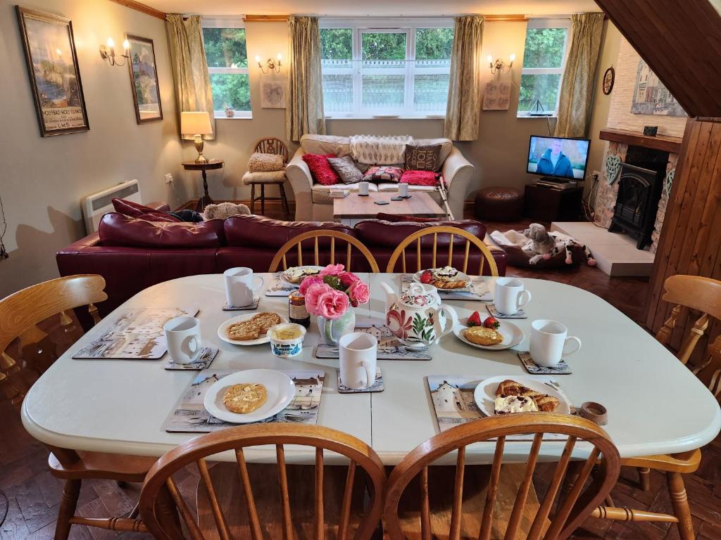einen Tisch mit Essen darauf im Wohnzimmer in der Unterkunft The Old School Caeathro, Snowdon, Eryri and Yr Wydffa Cottages in Caernarfon