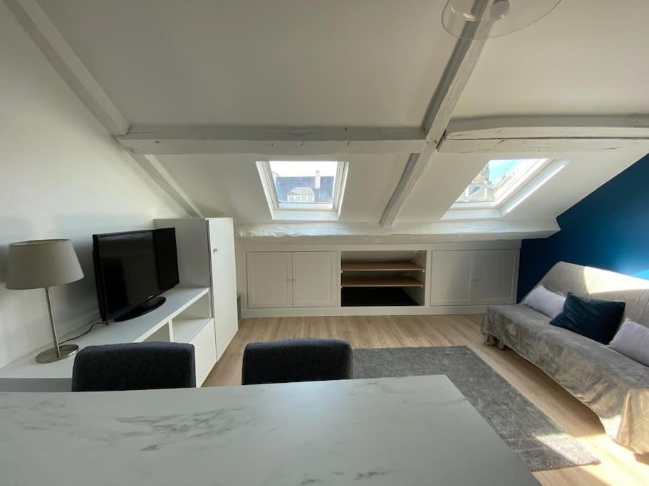 een woonkamer met een tafel en een bank bij Studio moderne en plein centre de Caen in Caen