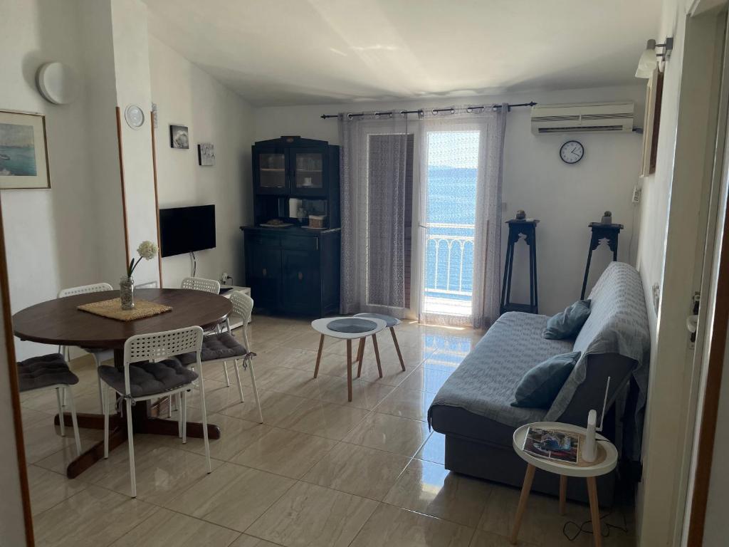 sala de estar con sofá y mesa en Apartman Gabrijel, en Podgora