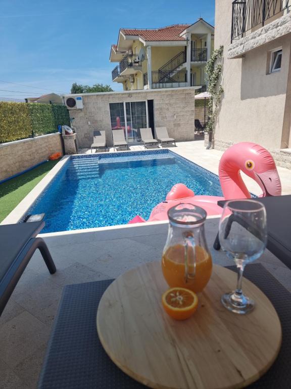 een drankje op een tafel naast een zwembad bij Villa with Pool & Garden apartment 2 Vuk in Tivat