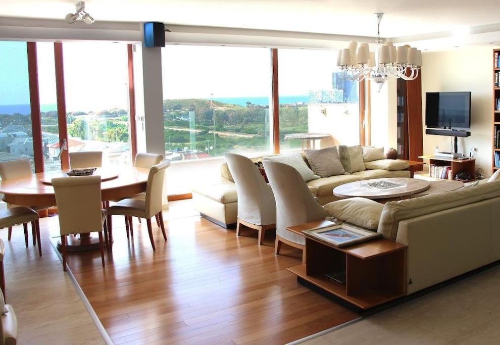 un soggiorno con divano e tavolo di Luxury Breathtaking Seafront Penthouse Duplex a Rishon LeẔiyyon
