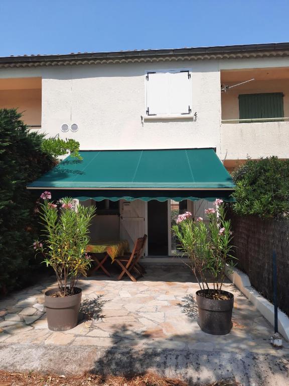 un auvent vert devant un bâtiment dans l'établissement Maison tout près du port et des restaurants de Saint Aygulf, à Saint-Aygulf