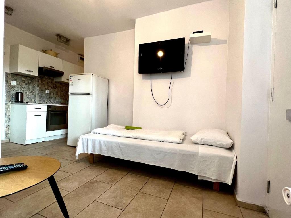 a kitchen with a bed with a tv on the wall at Familly Apartament 5 in Międzyzdroje