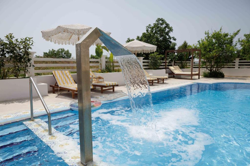 a pool with a water fountain in the middle at Maggana Residence in Minia