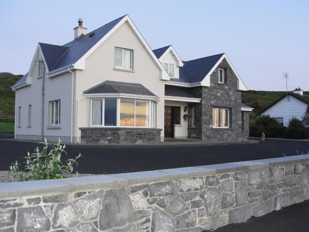 uma casa branca com uma parede de pedra em Island View Bed and Breakfast em Doolin