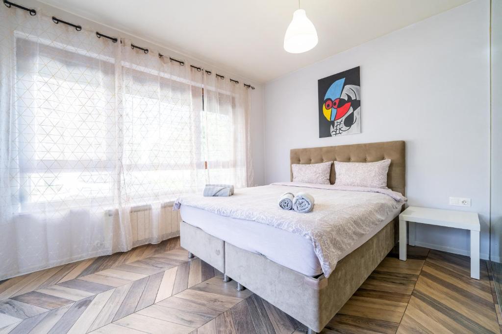 een slaapkamer met een groot bed en een raam bij Azurro Residence in Sofia