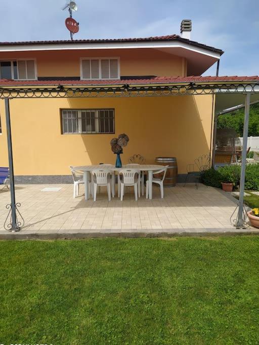 a patio with a table and chairs in front of a house at Taoretto 1 in Serravalle delle Langhe