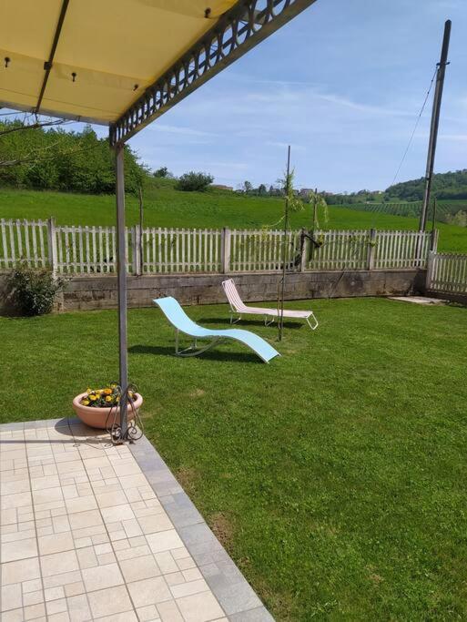 a patio with two chairs and a swing in a yard at Taoretto 1 in Serravalle delle Langhe