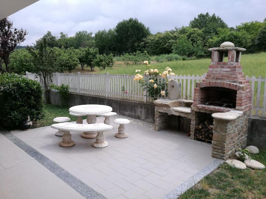 a patio with a brick oven and a picnic table at Taoretto 1 in Serravalle delle Langhe