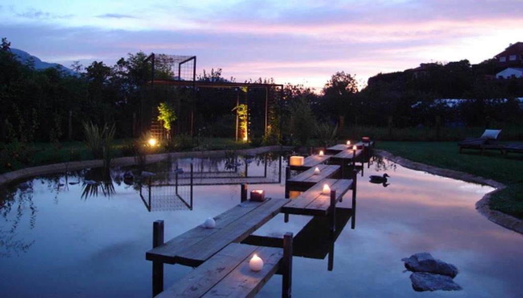 een rij banken in een vijver bij zonsondergang bij Las Villas de Cué in Llanes