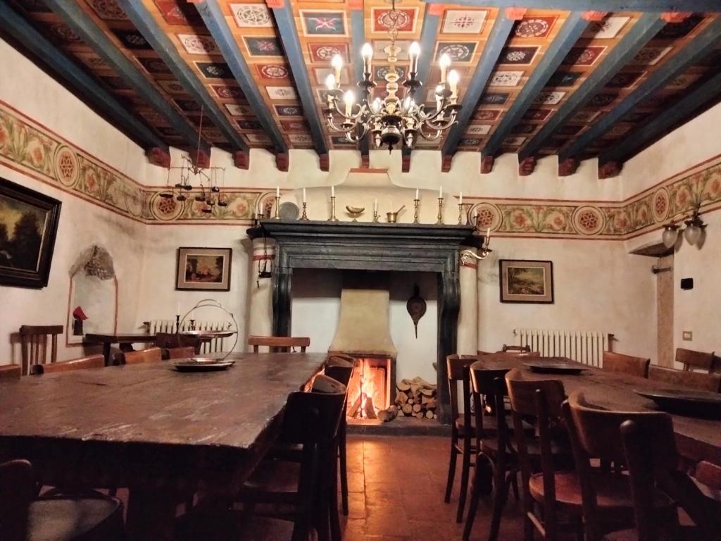 a dining room with a large table and a fireplace at DOSSENA Dimora Storica Al Lac Conte Tomaselli in Madonna della Costa