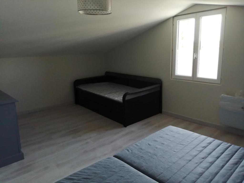 a room with a bed in a room with a window at Gite Bin Benaise sans linge in Pamproux