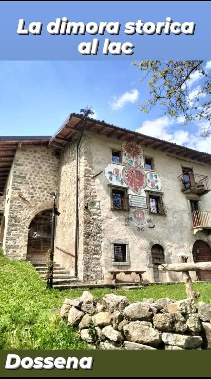 a stone building with a clock on the side of it at DOSSENA Dimora Storica Al Lac Conte Tomaselli in Madonna della Costa