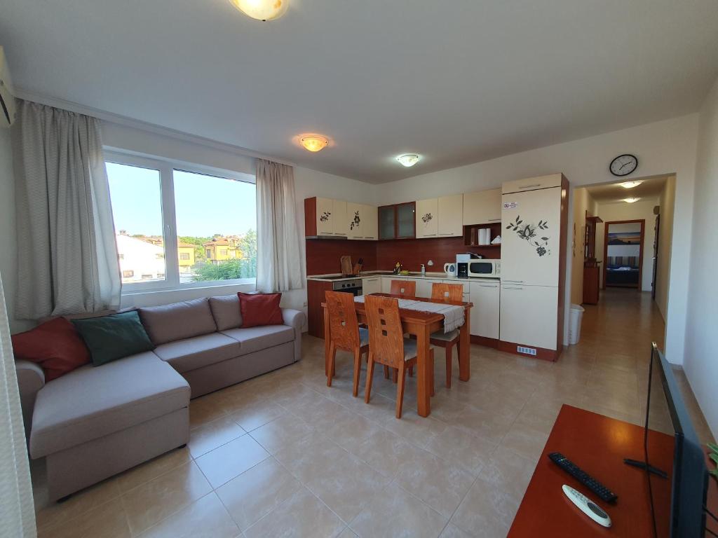 Una sala de estar con un sofá y una mesa y una cocina. en Cozy, spacious apartment near Paradise Bay, en Sozopol