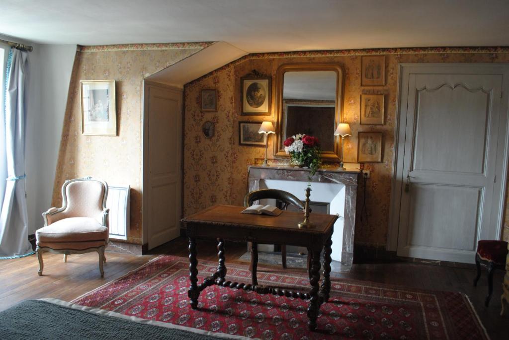 a living room with a desk and a fireplace at Le Ragois in Richelieu