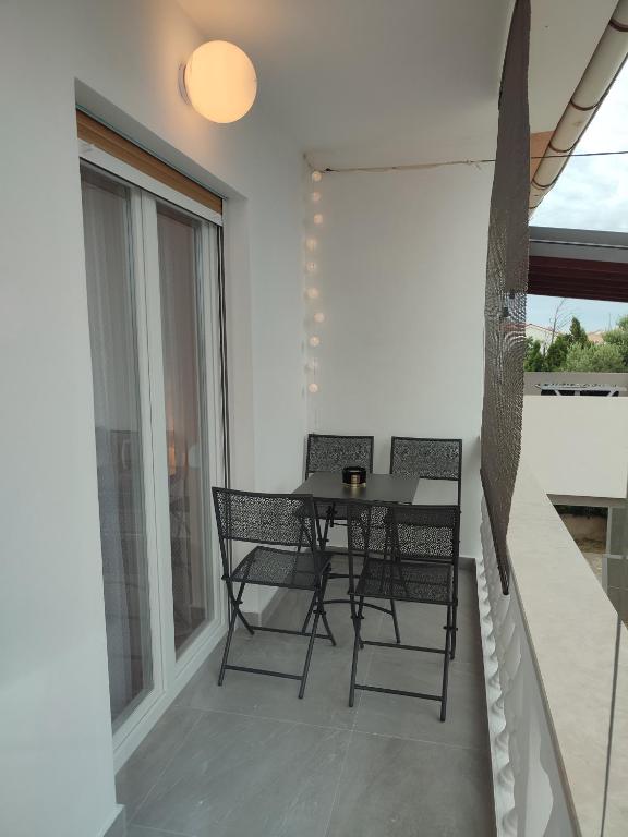 a patio with a table and chairs on a balcony at Povljana Maris in Povljana
