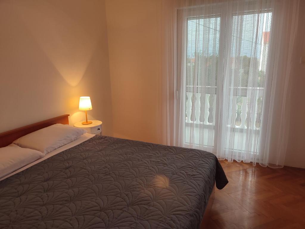 1 dormitorio con cama y ventana grande en Povljana Maris en Povljana