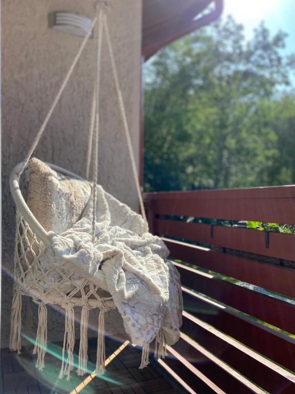 a hanging chair with a pillow on a porch at Kitas krantas in Juodkrantė