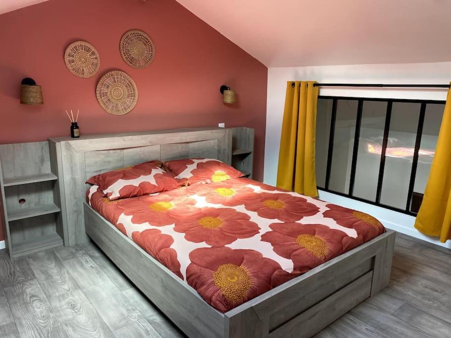 - une chambre avec un lit et une couette en fleurs dans l'établissement Joli T2 à 1km de la chambre d'amour, à Anglet
