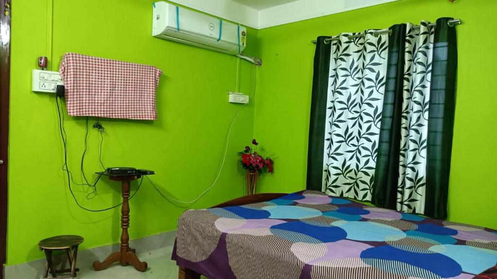 a bedroom with green walls and a bed in a room at Shanti Kunj Homestay in Agartala