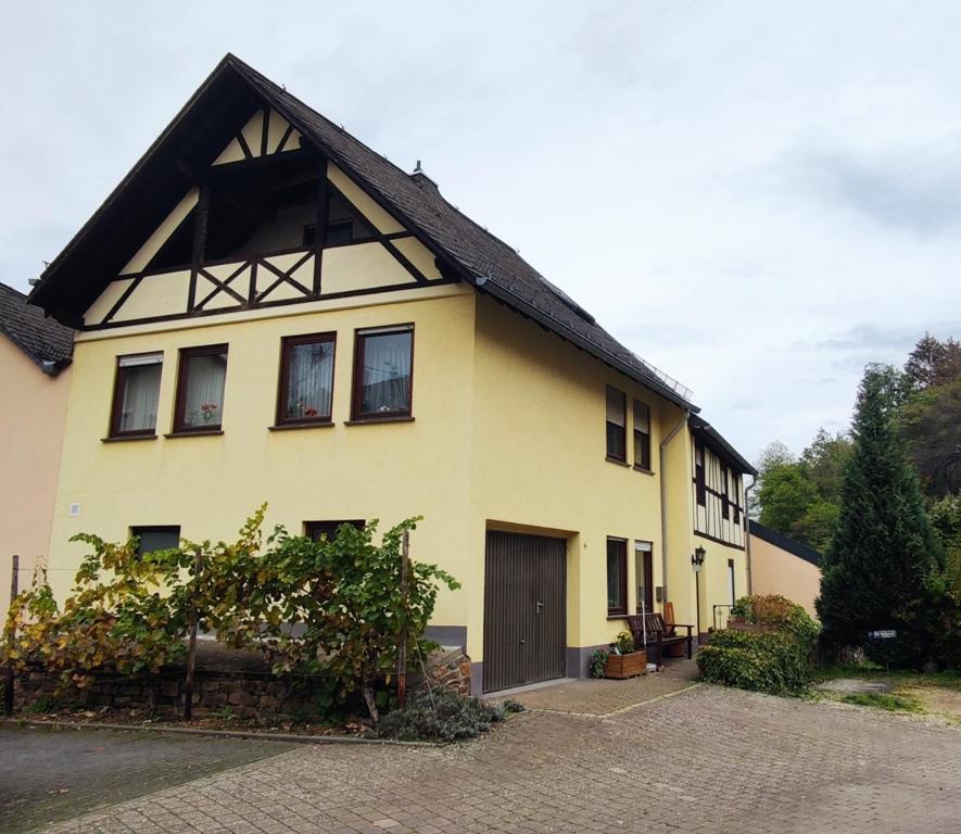 a yellow house with a black roof at Ferienhaus am Marktplatz in Oberheimbach