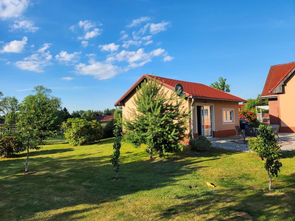 ein Haus mit einem Garten mit Bäumen davor in der Unterkunft Słoneczny Domek in Podgórzyn