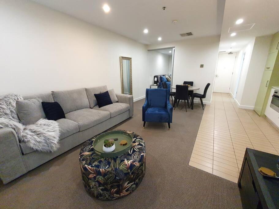 a living room with a couch and a table at Colley 11-11 Sub-Penthouse Luxurious Glenelg in Glenelg