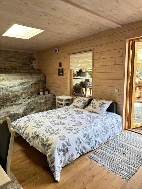 ein Schlafzimmer mit einem Bett in einer Holzhütte in der Unterkunft Natura Sauna in Laulasmaa