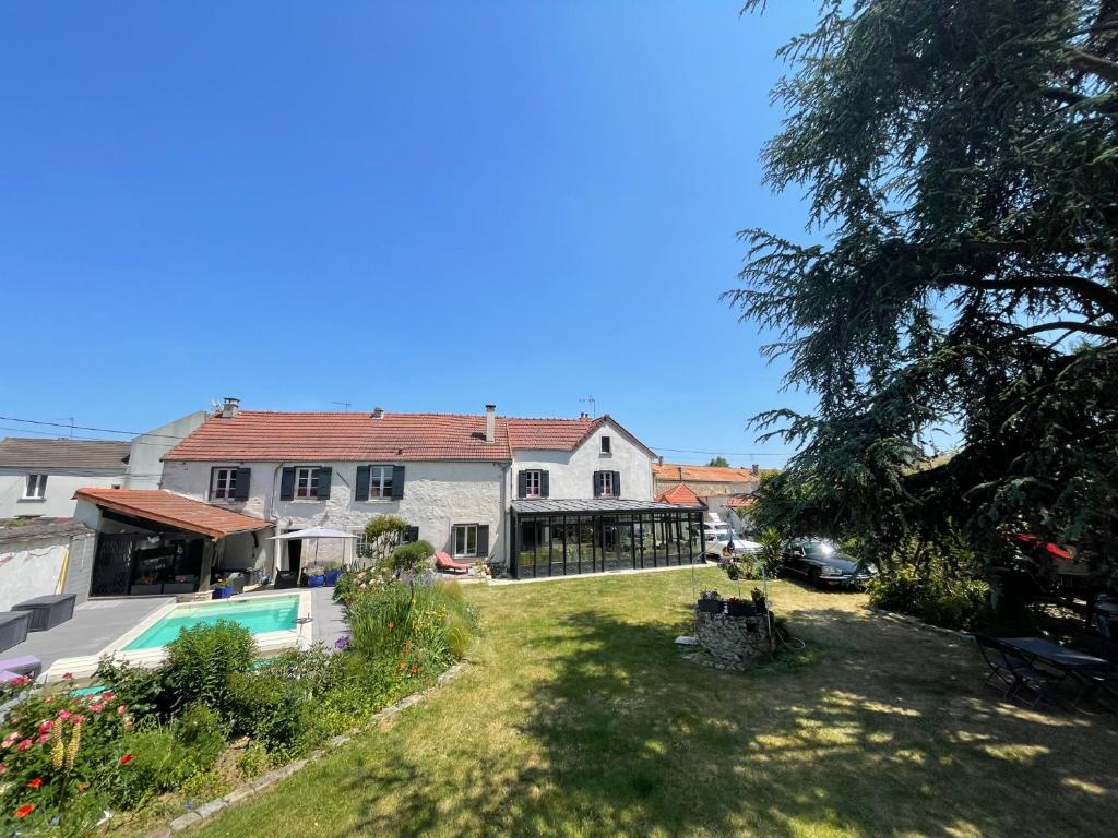 a house with a yard with a swimming pool at La demeure de Liers in Sainte-Geneviève-des-Bois