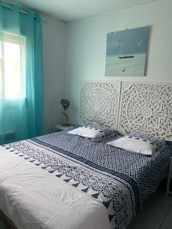 a bedroom with a large bed with blue walls at Les Corsaires direct plage près du port in Saint Pierre La Mer