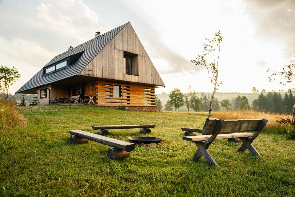 a log cabin with a bench and a picnic table at Chalupa Záhorka in Orlické Záhoří 