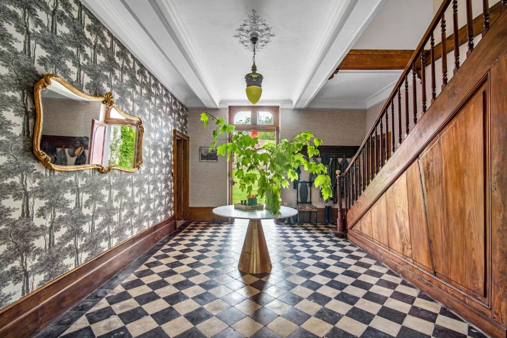 - un couloir avec une table et une plante dans l'établissement Château de Gouyas, à Montagrier